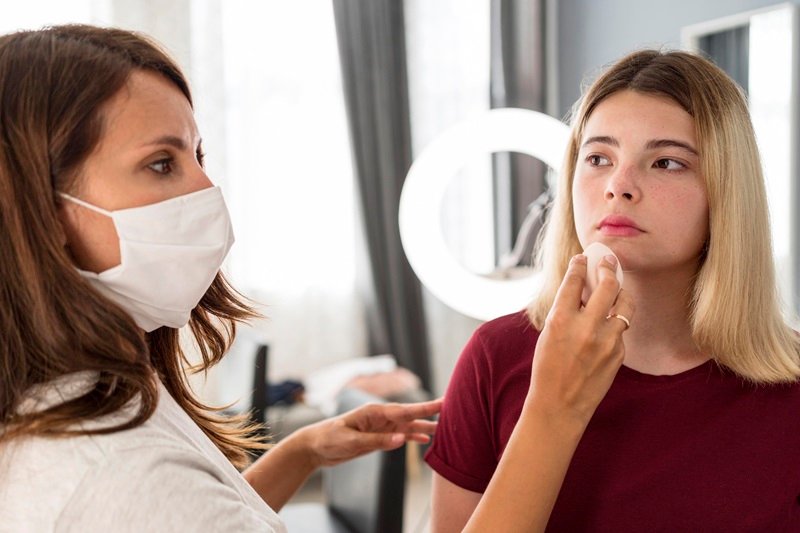 Professional assessing uneven lip filler results